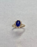 Oval-Cut Yellow Gold Tanzanite ring accented with a diamond halo