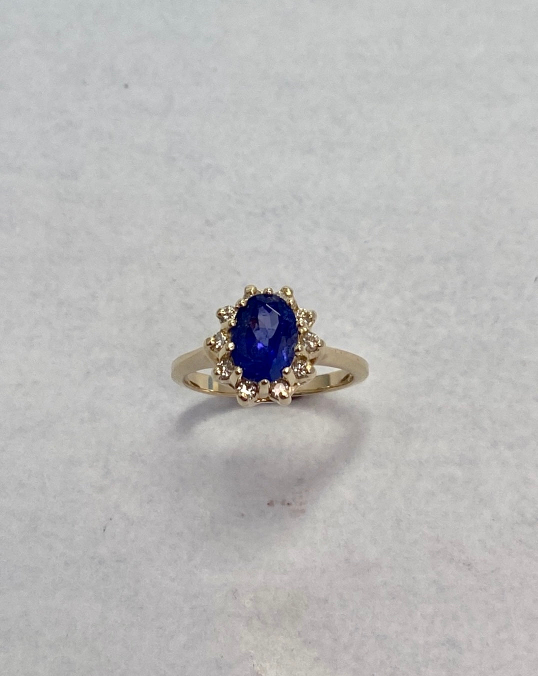 Oval-Cut Yellow Gold Tanzanite ring accented with a diamond halo